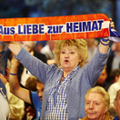 Frau mit Schal "Aus Liebe zur Heimat" im Publikum